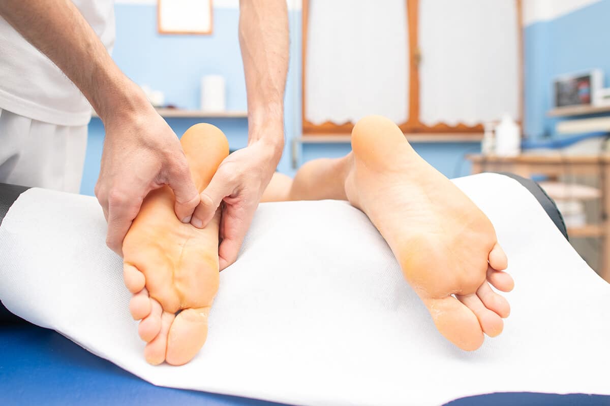 swedish or shiatsu massage - therapist-s-hands-massaging-male-foot